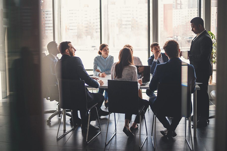 Solutions - Professionals Working in Conference Room Next to a Large Window on a Nice Day